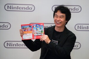 Shigeru Miyamoto showing the New Super Mario Bros. Wii cover